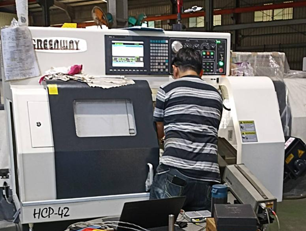 An operator using a CNC lathe.